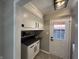 Mud room with white cabinets, black hardware, gray countertops, and access to the back yard at 2845 12Th St, Columbus, IN 47201