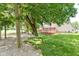 Expansive backyard featuring mature trees, a red wooden deck, and well-maintained lawn at 3067 Stilton Dr, Cicero, IN 46034