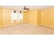 Sunny bedroom showcasing neutral carpet, yellow walls, ceiling fan, and bright windows at 3067 Stilton Dr, Cicero, IN 46034