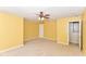 Bedroom featuring neutral carpet, yellow walls, ceiling fan, and a doorway to another room at 3067 Stilton Dr, Cicero, IN 46034