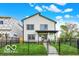 Charming two-story home with black fence, lush lawn, and bright, inviting curb appeal at 35 N Keystone Ave, Indianapolis, IN 46201