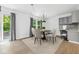 Dining room featuring modern chandelier, backyard access, and sleek gray cabinets at 4223 Kestrel Ct, Indianapolis, IN 46254