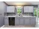 Functional kitchen with gray cabinets, sleek backsplash, and access to the backyard at 4223 Kestrel Ct, Indianapolis, IN 46254