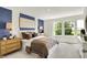 Bright bedroom featuring blue accent wall, neutral tones, charming decor, and ample natural light from the windows at 4379 Red Pine Dr, Bargersville, IN 46106