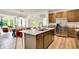 Bright, open kitchen features a large island with seating, stainless steel refrigerator, and a view into the dining area at 4379 Red Pine Dr, Bargersville, IN 46106