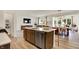 Kitchen island features a stainless steel dishwasher and sink, with an open view of the dining and living spaces at 4379 Red Pine Dr, Bargersville, IN 46106