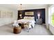 Stylish main bedroom featuring a dark accent wall, soft lighting, and comfortable seating area at 4379 Red Pine Dr, Bargersville, IN 46106
