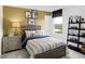 Well-lit bedroom features comfortable queen bed, industrial nightstand, and natural sunlight from a large window at 4382 Red Pine Dr, Bargersville, IN 46106