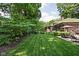 Expansive backyard features lush lawn, mature trees, and a patio with outdoor seating at 4455 Broadway St, Indianapolis, IN 46205