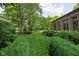 Lush backyard featuring a well-manicured lawn and mature trees surrounding the property at 4455 Broadway St, Indianapolis, IN 46205