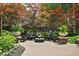 Relaxing backyard patio with Adirondack chairs surrounding a fire pit, accented by colorful foliage at 4455 Broadway St, Indianapolis, IN 46205