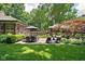 Beautifully landscaped backyard with a brick patio, dining area, and well-maintained lawn at 4455 Broadway St, Indianapolis, IN 46205