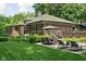 Spacious backyard featuring a patio with lounge chairs, dining set, and lush garden landscaping at 4455 Broadway St, Indianapolis, IN 46205