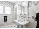 Charming bathroom featuring subway tiles, a pedestal sink, and black and white wallpaper at 4455 Broadway St, Indianapolis, IN 46205