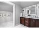 Bright bathroom features a double sink vanity, marble counters, a large mirror, and seamless access to the shower area at 4455 Broadway St, Indianapolis, IN 46205