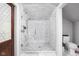Modern bathroom with glass shower enclosure, stylish fixtures, and white marble tile at 4455 Broadway St, Indianapolis, IN 46205