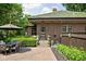 Home exterior features a brick patio with outdoor dining space and manicured landscaping at 4455 Broadway St, Indianapolis, IN 46205
