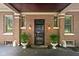 Front entrance features a decorative security door, brick facade, and manicured planters at 4455 Broadway St, Indianapolis, IN 46205