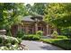 Beautiful brick home with a green tile roof, manicured landscaping, and inviting front entrance at 4455 Broadway St, Indianapolis, IN 46205