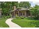 Charming brick home with a green tile roof, landscaped yard, and a winding walkway at 4455 Broadway St, Indianapolis, IN 46205