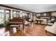 Spacious living room with hardwood floors, a piano, fireplace, and detailed woodwork at 4455 Broadway St, Indianapolis, IN 46205