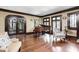 Inviting living room featuring hardwood floors, large windows, and a grand piano at 4455 Broadway St, Indianapolis, IN 46205