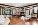 Inviting living room featuring hardwood floors, large windows, and a grand piano at 4455 Broadway St, Indianapolis, IN 46205