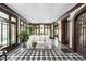 Spacious sunroom featuring checkered tile, white sofa, and multiple windows for ample natural light at 4455 Broadway St, Indianapolis, IN 46205