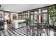Bright sunroom with checkered tile flooring, floor-to-ceiling windows, and access to additional rooms at 4455 Broadway St, Indianapolis, IN 46205