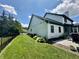 View of a spacious, grassy backyard with a well-maintained lawn and a white house featuring a dark green roof at 4655 Rockcress Ct, Zionsville, IN 46077
