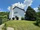 Side view of a white house with a brick chimney, green lawn, and bordered with black metal fencing at 4655 Rockcress Ct, Zionsville, IN 46077