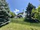 View of a charming backyard with a lush green lawn, framed by mature trees, and secured by a black metal fence at 4655 Rockcress Ct, Zionsville, IN 46077