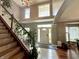 Elegant foyer with hardwood floors, a staircase with vine accents, and a bright, welcoming entrance bathed in natural light at 4655 Rockcress Ct, Zionsville, IN 46077