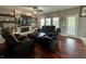 Inviting living room with stone fireplace, floating shelves, and dark leather seating at 4655 Rockcress Ct, Zionsville, IN 46077