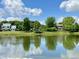 Scenic view of a serene pond reflecting nearby houses and trees under a partly cloudy sky at 4655 Rockcress Ct, Zionsville, IN 46077