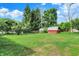 Spacious backyard features green lawn and a red storage shed at 5015 Nowland Ave, Indianapolis, IN 46201
