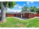 Backyard with brick exterior, large tree, and grassy lawn at 5015 Nowland Ave, Indianapolis, IN 46201
