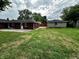 The backyard with the house and detached garage and a large green lawn at 5015 Nowland Ave, Indianapolis, IN 46201