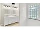 Bright bathroom with double vanity, shower, and glass block window at 5015 Nowland Ave, Indianapolis, IN 46201