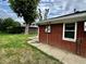 Brick ranch style home with a sidewalk running along the side of the house and green grass at 5015 Nowland Ave, Indianapolis, IN 46201
