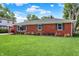 Brick house on a grassy lot, enhanced by a garden and manicured landscape at 5015 Nowland Ave, Indianapolis, IN 46201