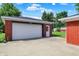 View of the detached garage with a white door and brick exterior at 5015 Nowland Ave, Indianapolis, IN 46201