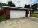 Garage has a white door and a small white side door and the address is above the garage door at 5015 Nowland Ave, Indianapolis, IN 46201