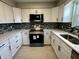 Bright kitchen featuring white cabinets, modern appliances, updated countertops, and decorative tile backsplash at 5015 Nowland Ave, Indianapolis, IN 46201