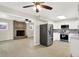 Open concept kitchen with stainless steel appliances, modern backsplash, and stone fireplace feature in the living room at 5015 Nowland Ave, Indianapolis, IN 46201
