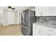 Open kitchen featuring stainless steel refrigerator, white cabinets, and access to the living area at 5015 Nowland Ave, Indianapolis, IN 46201