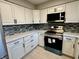 Bright kitchen featuring white cabinets, modern appliances, stylish backsplash, and new countertops at 5015 Nowland Ave, Indianapolis, IN 46201