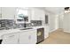 Contemporary kitchen featuring stainless steel dishwasher, black faucet, and white cabinetry at 5015 Nowland Ave, Indianapolis, IN 46201