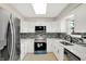 Modern kitchen with stainless steel appliances, white cabinets, quartz countertops, and mosaic backsplash at 5015 Nowland Ave, Indianapolis, IN 46201