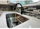 Close-up of a kitchen sink with modern faucet, tiled backsplash, and white countertop at 5015 Nowland Ave, Indianapolis, IN 46201